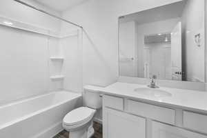 Full bathroom featuring hardwood / wood-style flooring, vanity, shower / bathtub combination, and toilet