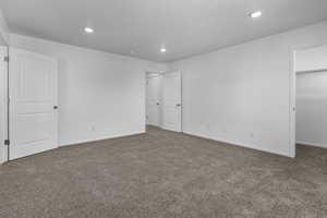 Unfurnished bedroom with carpet flooring, a walk in closet, and a closet