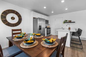 Dining area with dark hardwood / wood-style floors and sink