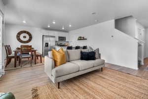 Living room with a textured ceiling, light hardwood / wood-style flooring, and sink