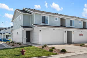 View of front of property with a garage and a front lawn