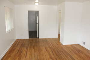 Unfurnished room featuring dark wood-type flooring