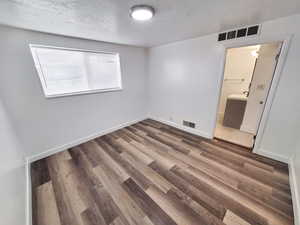 Unfurnished bedroom featuring hardwood / wood-style floors, ensuite bathroom,