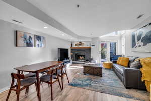 Living room featuring a fireplace, a textured ceiling, and light hardwood / wood-style flooring