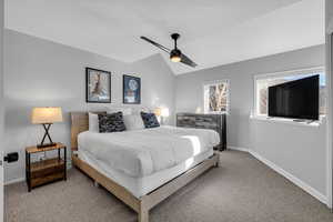 Bedroom featuring ceiling fan, carpet, and lofted ceiling