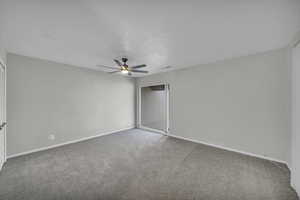 Carpeted spare room with ceiling fan