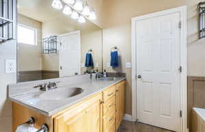 Bathroom featuring a sink, double vanity, and tile patterned flooring