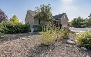 View of front of home with stone siding, stucco siding, and fence