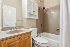 Bathroom Two featuring shower / bath combination with curtain, vanity, and toilet