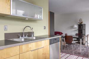 Kitchen featuring dishwasher, light brown cabinets, and sink