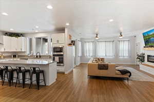 Kitchen featuring white cabinets, sink, light hardwood / wood-style flooring, ceiling fan, and stainless steel appliances