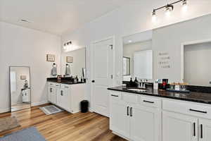 Bathroom featuring hardwood / wood-style flooring, vanity, and an enclosed shower