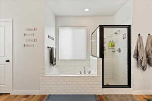 Bathroom with plus walk in shower and wood-type flooring