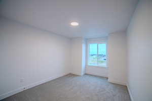 Carpeted empty room with baseboards