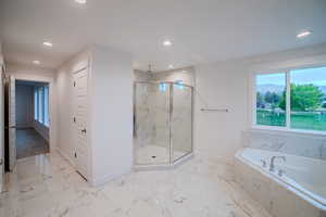 Bathroom with a marble finish shower, baseboards, and recessed lighting