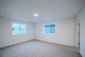 Unfurnished room with light colored carpet and baseboards