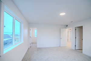Empty room featuring light carpet, baseboards, and visible vents