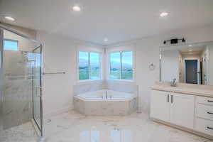 Full bathroom with a garden tub, baseboards, and a healthy amount of sunlight
