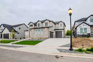 View of front of property featuring concrete driveway, board and batten siding, and an attached garage
