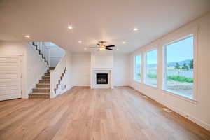 Unfurnished living room with visible vents, recessed lighting, stairway, ceiling fan, and light wood-style flooring