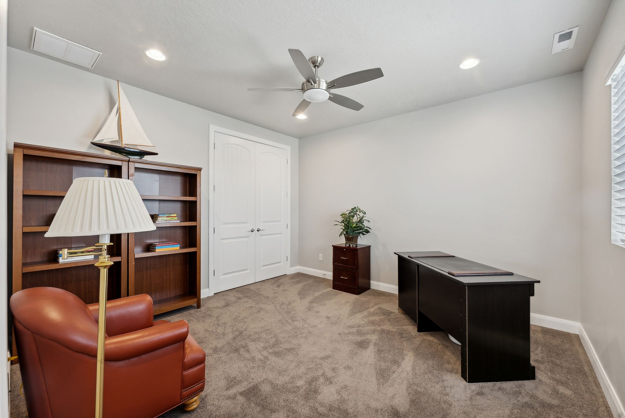 Home office featuring carpet flooring and ceiling fan