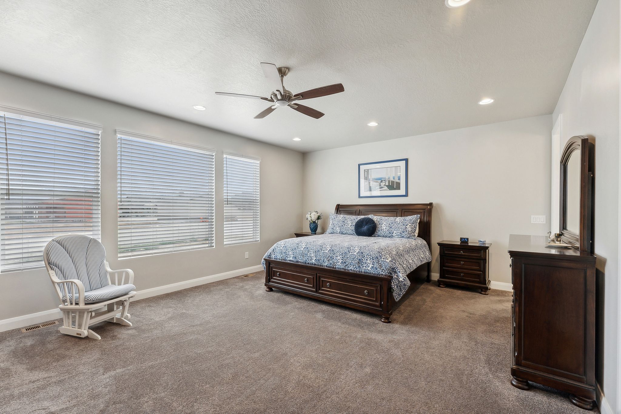 Primary bedroom suite. Carpeted bedroom featuring a textured ceiling and ceiling fan