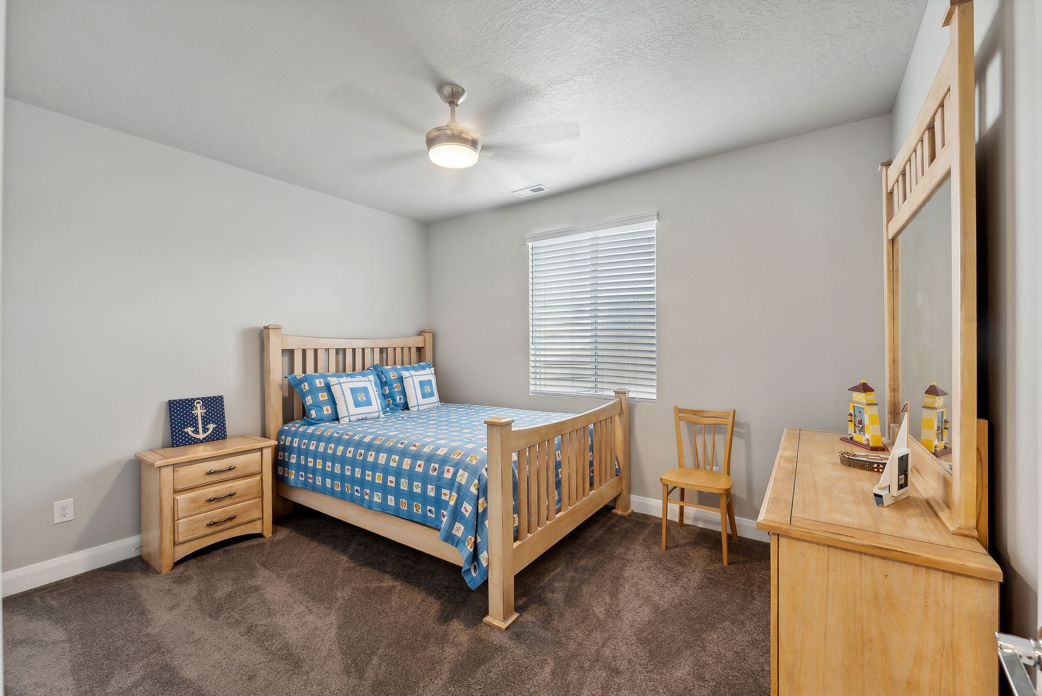 Bedroom featuring ceiling fan, a textured ceiling, and dark colored carpet