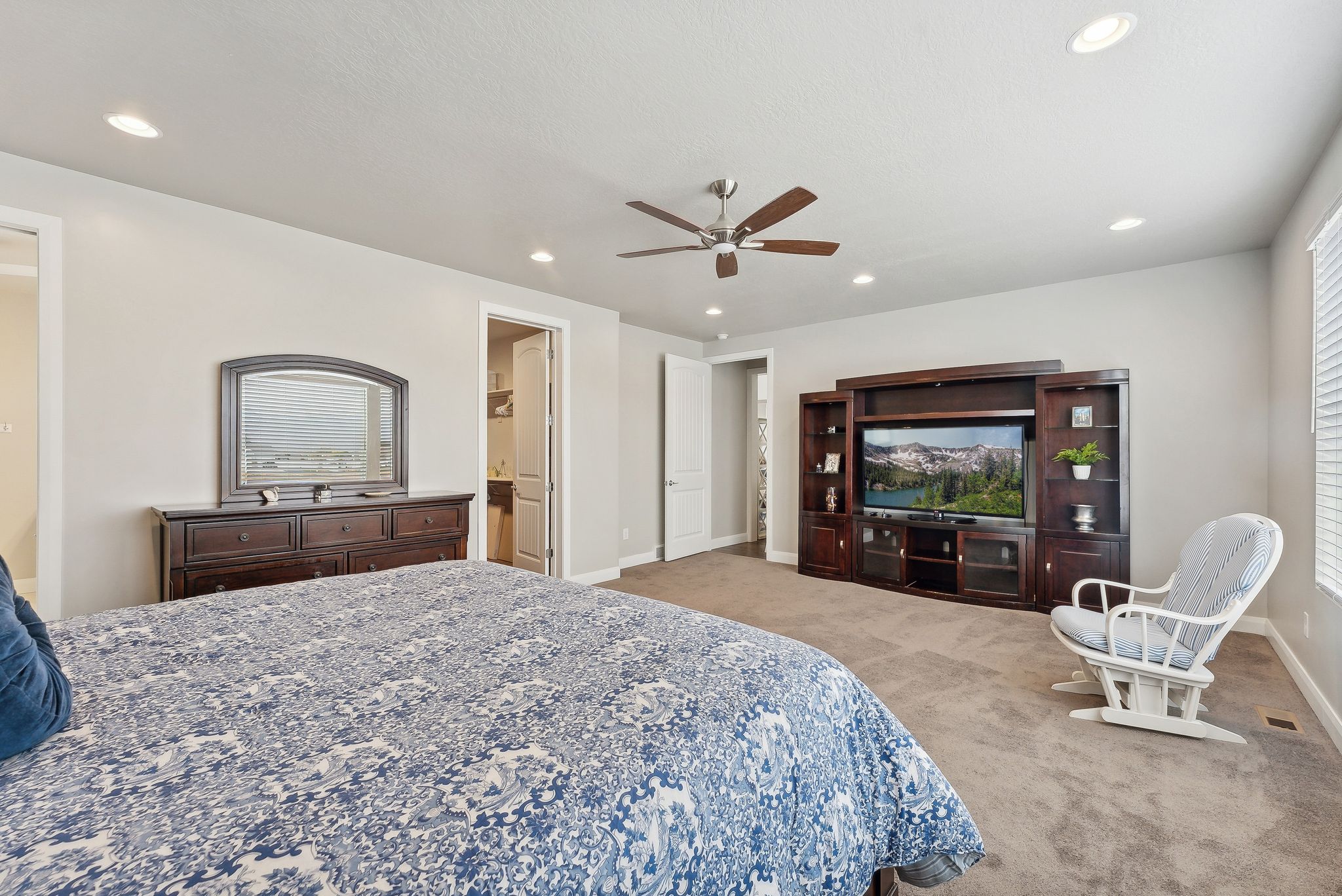 Primary Bedroom suite with ceiling fan and light colored carpet