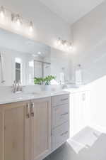 Bathroom with walk in shower, tile patterned floors, and vanity