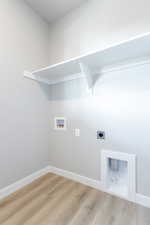 Washroom with hookup for a washing machine, light hardwood / wood-style flooring, and electric dryer hookup