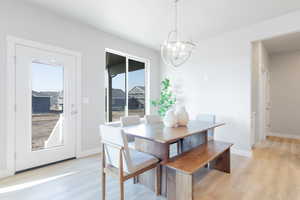 Dining room featuring plenty of natural light, light hardwood / wood-style floors, and a chandelier