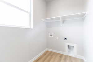 Laundry area featuring hookup for an electric dryer, hookup for a washing machine, and light wood-type flooring