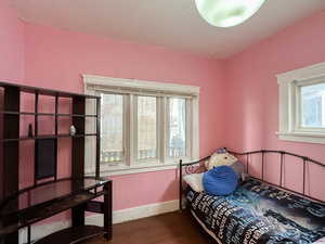 Bedroom with hardwood / wood-style flooring and a textured ceiling