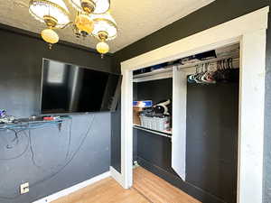 Unfurnished bedroom with hardwood / wood-style floors, a textured ceiling, and a closet