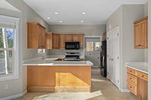 Kitchen featuring light tile patterned flooring, sink, kitchen peninsula, and stainless steel appliances