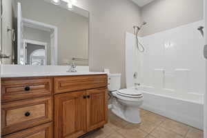 Full bathroom with tile patterned flooring, vanity, toilet, and shower / washtub combination