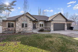 View of front of property with a front yard and a garage