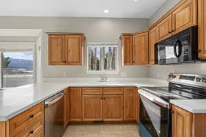 Kitchen featuring light tile patterned flooring, appliances with stainless steel finishes, plenty of natural light, and sink