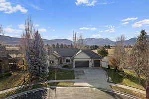 View of front facade with a mountain view, a garage, and a front lawn