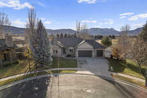 View of front of house with a mountain view, a garage, and a front yard