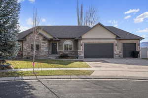 View of front facade featuring a garage and a front lawn