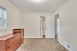 main floor  bedroom with light carpet and a closet