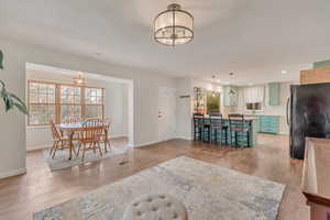 Living room featuring light wood-type flooring and a notable chandelier