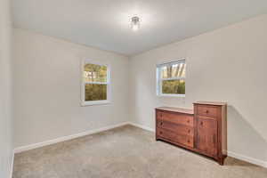 Carpeted bedroom featuring plenty of natural light