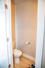 Bathroom featuring a textured ceiling, hardwood / wood-style flooring, and toilet