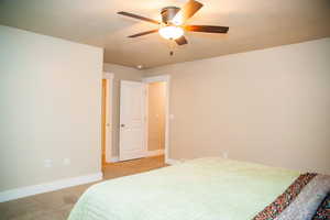 Carpeted bedroom with ceiling fan