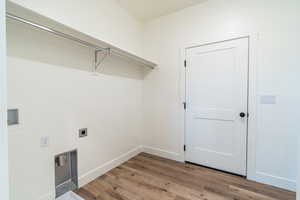 Laundry area with hookup for an electric dryer, wood-type flooring, and hookup for a washing machine