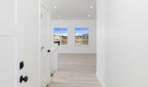 Hallway with light hardwood / wood-style flooring