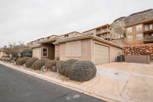 View of front facade with central AC and a garage