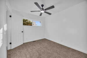 Empty room featuring carpet flooring and ceiling fan